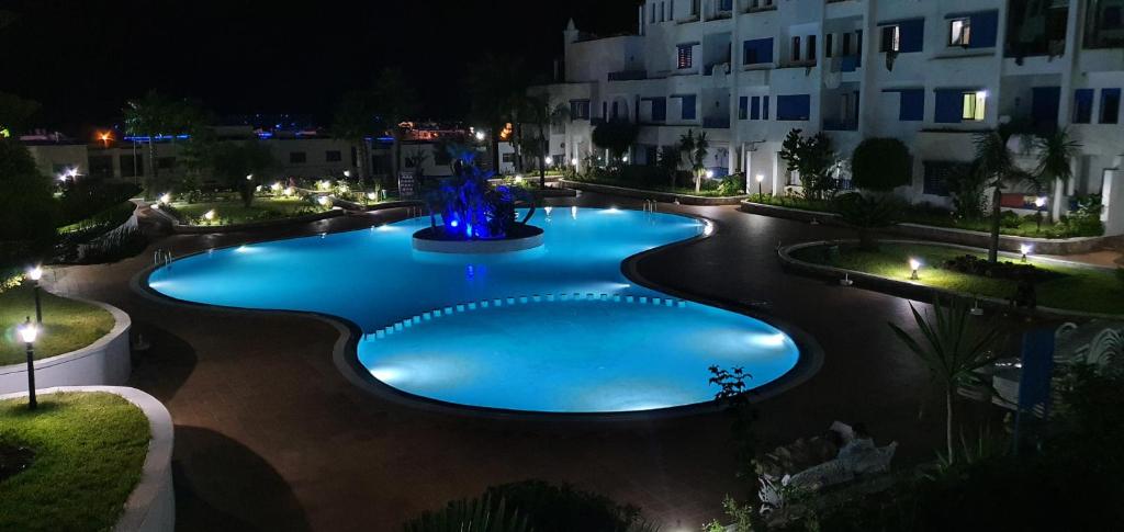 een groot zwembad met een fontein in de nacht bij KABILA VISTA n3 in M'diq