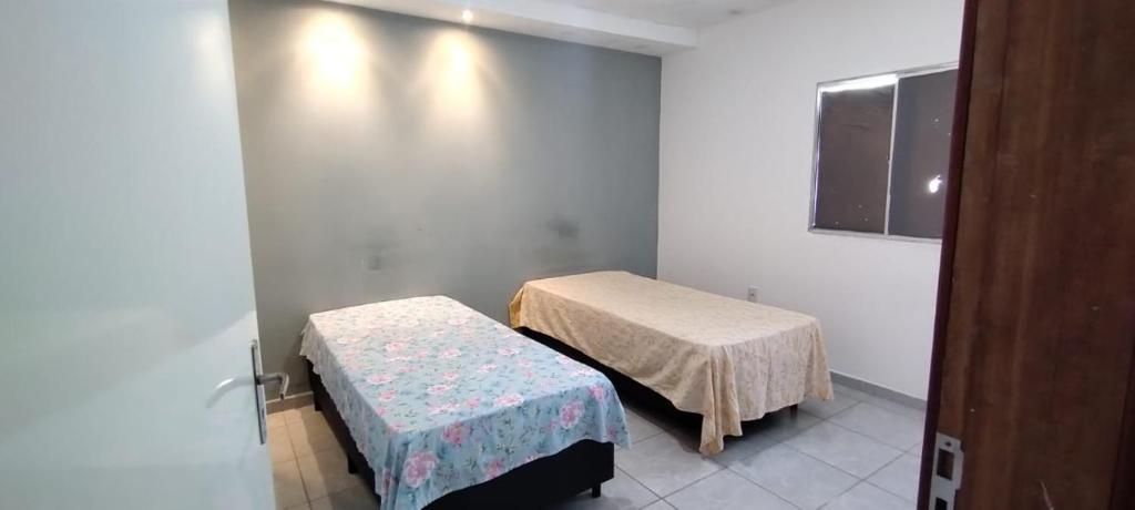 a hospital room with two beds and a window at QUARTO COM BANHEIRO PARA ALUGAR POR DIÁRIA in Garanhuns