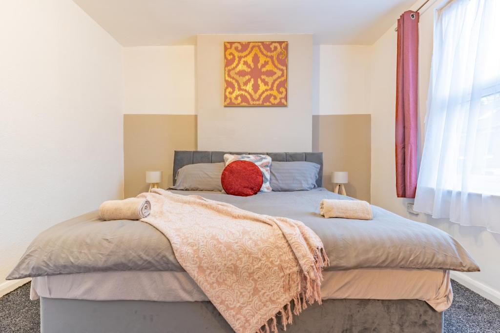 a bedroom with a bed with two pillows on it at STAYZED R - Urban Oasis NG7, Walking Distance From City Centre & Lots of Amenities - Large bedrooms, Perfect for Work, Tourism, Family and Contractors - Long Stays Welcome in Nottingham