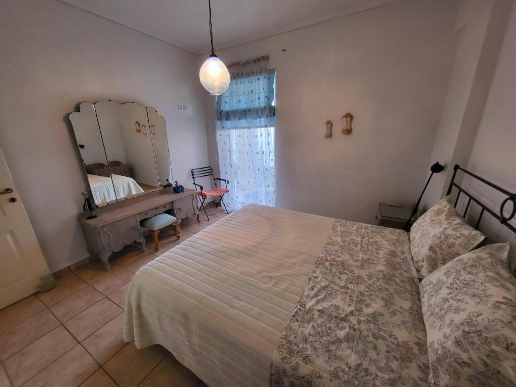 a bedroom with a bed and a desk and a mirror at Dilion Guest Apartment in Dhílesi