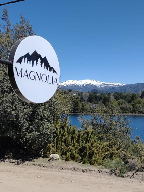 un cartel con vistas al lago y a las montañas en Cabañas Magnolia en Villa Pehuenia