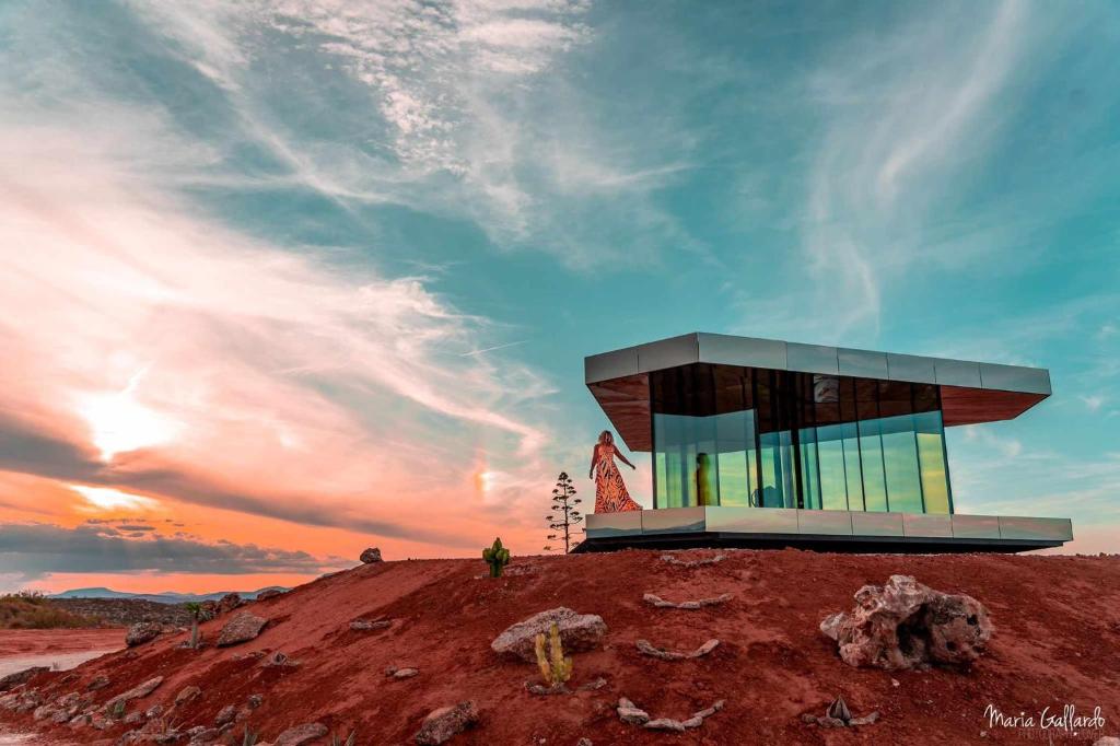 a building on top of a hill with a sunset at La Casa del Desierto in Gorafe