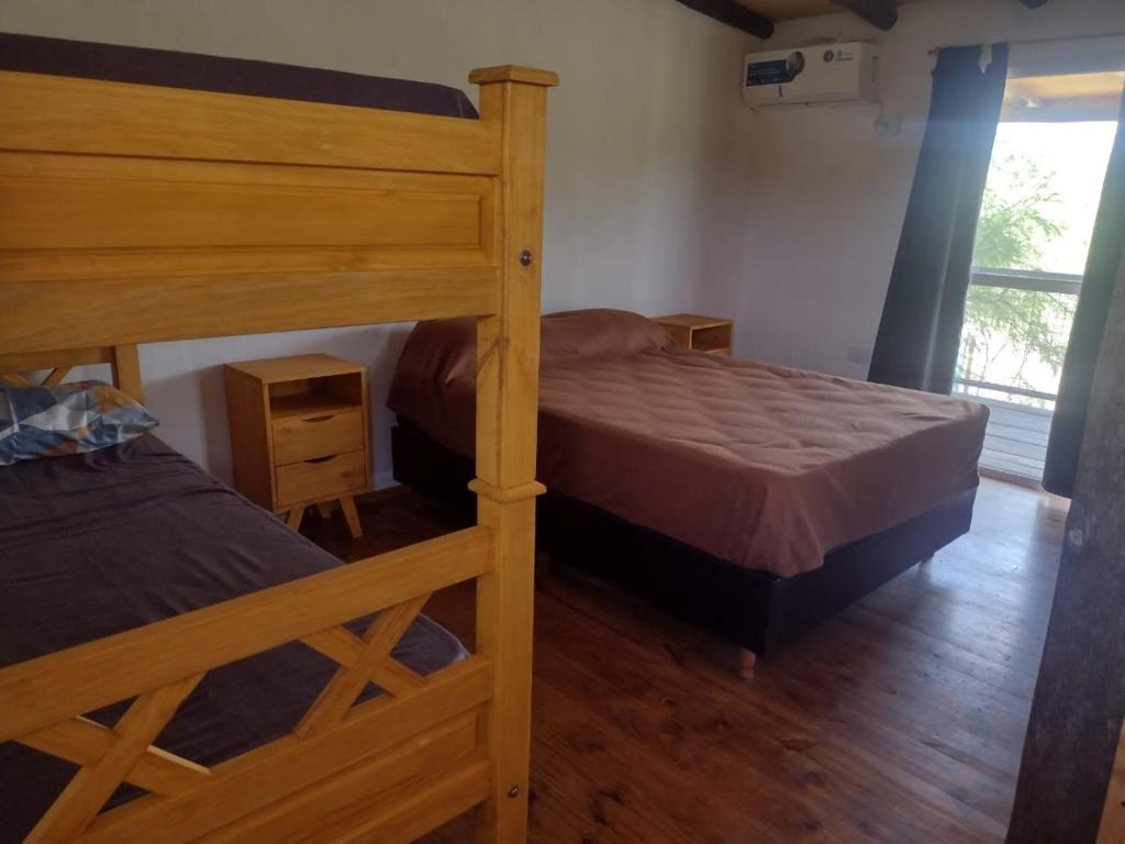 1 Schlafzimmer mit 2 Etagenbetten und einem Fenster in der Unterkunft Cabaña árbol de Nonsacate in San Marcos Sierras