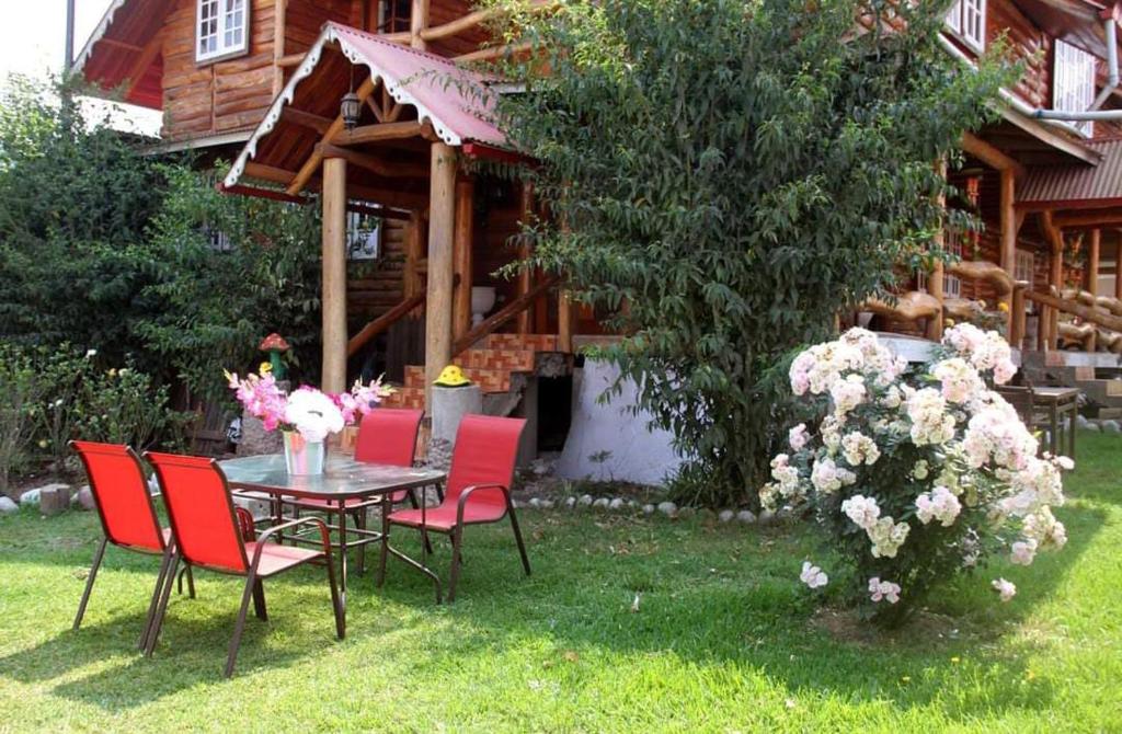 una mesa y sillas frente a una casa en Hospedaje Lojada, en Oxapampa