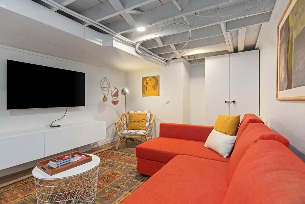 uma sala de estar com um sofá vermelho e uma televisão de ecrã plano em Mid-Century Vibes Nest em Seattle