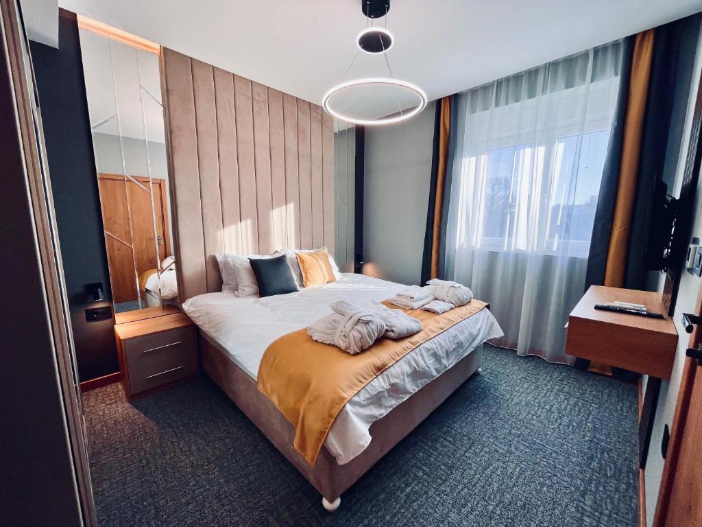 een slaapkamer met een groot bed en een groot raam bij MOZAIK Apartments & Spa - Modern Apartments with Exclusive Spa Wellness in the City Center, Free Parking, Wi-FI, Sauna, Jacuzzi, Salt Wall in Ćuprija