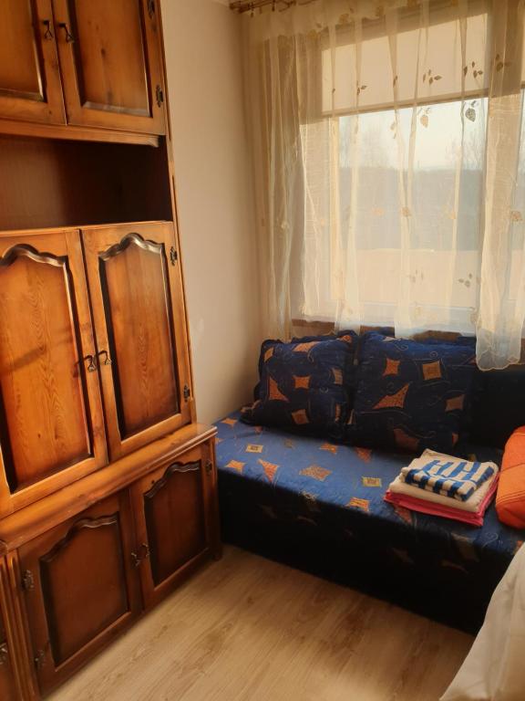Habitación pequeña con cama y ventana en Apartament Laurka, en Kamienna Góra
