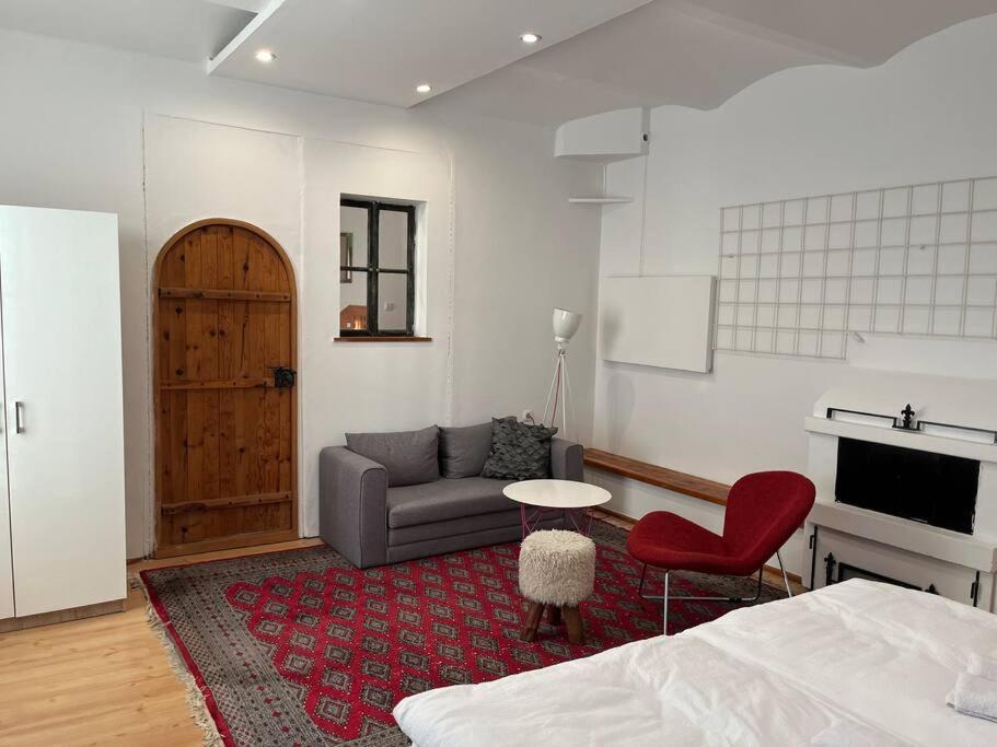 een woonkamer met een bank en een rode stoel bij Srce Sarajeva in Sarajevo