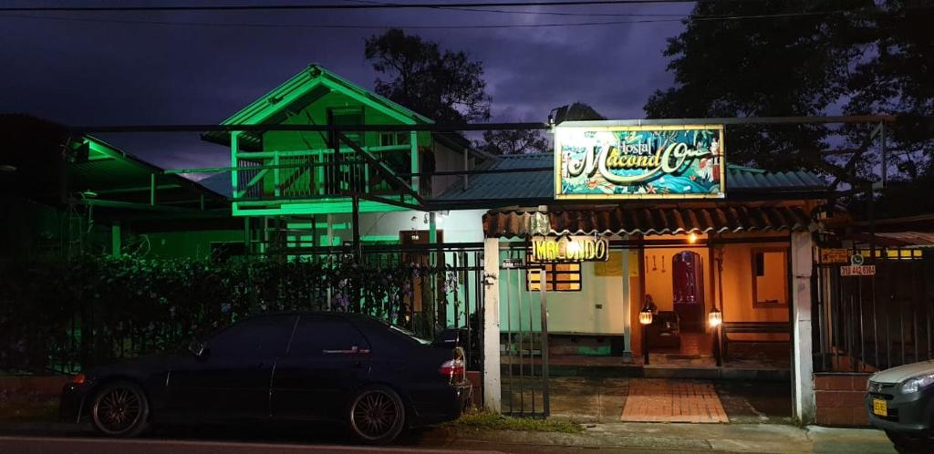 um carro estacionado em frente a um edifício à noite em HOSTAL MACONDO em Manizales