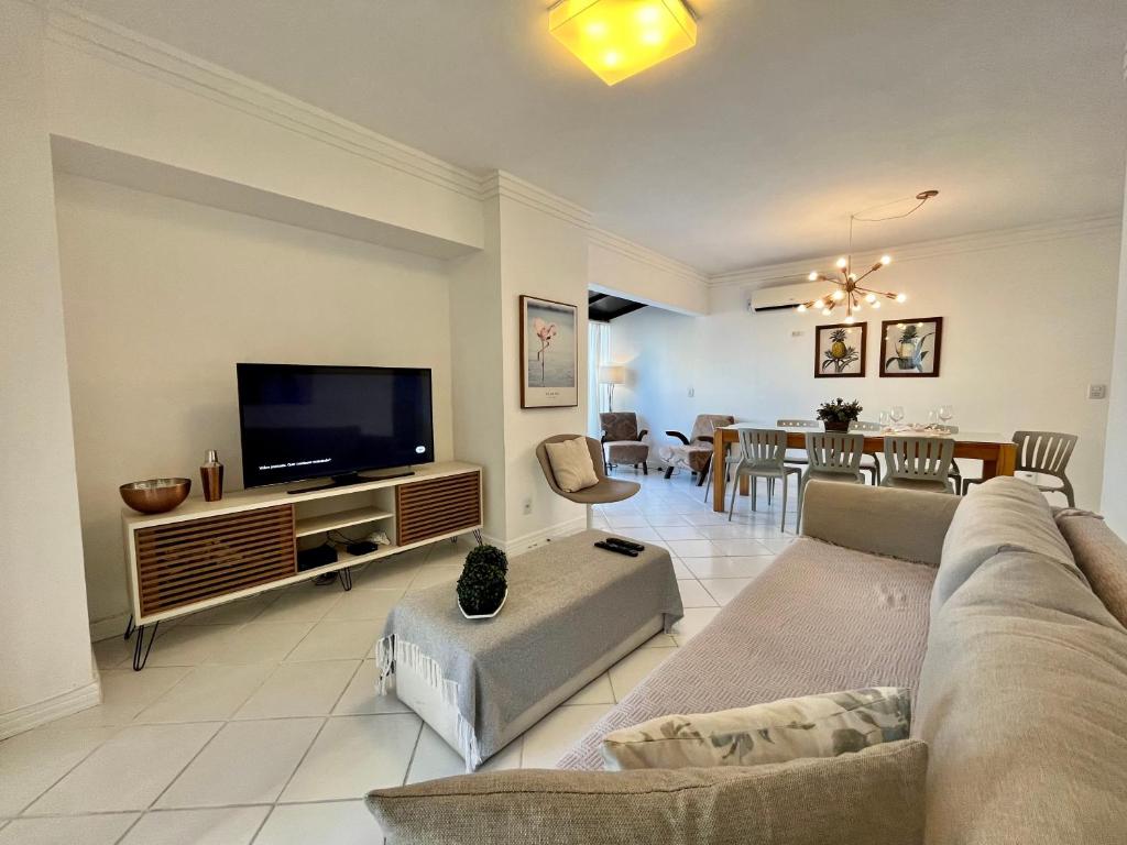 sala de estar con sofá y TV de pantalla plana en Cobertura Baixa Coral Gables, en Balneário Camboriú