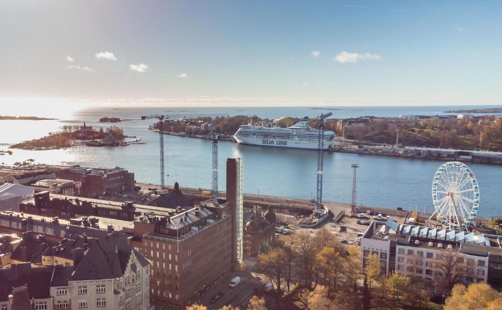 a large cruise ship is docked in a river at Modern apartment in a prime location in Helsinki