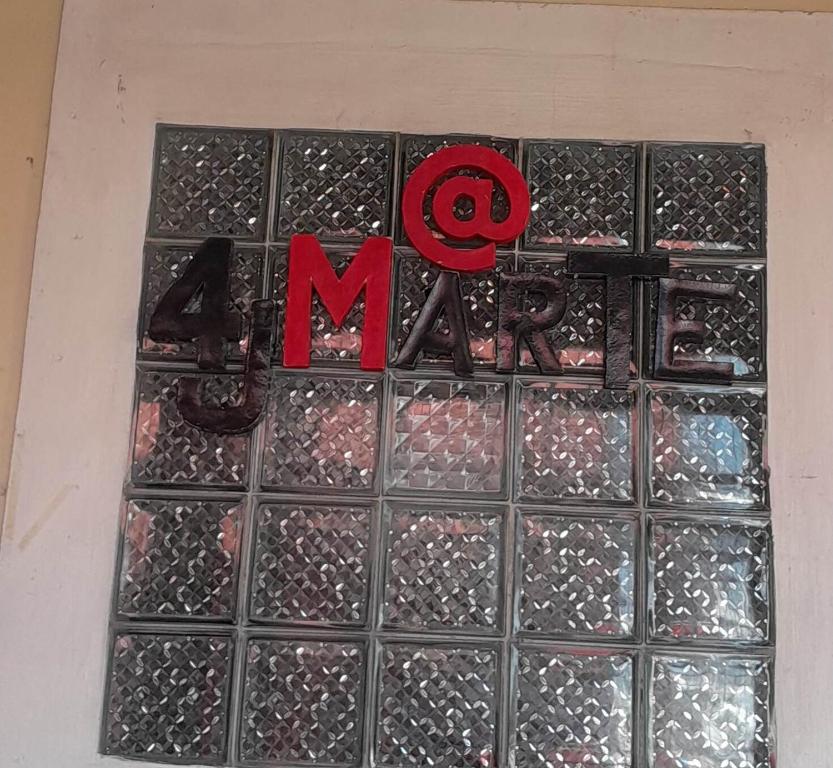 a glass block wall with the letter m on it at 4jMarte Home Stay in Imus