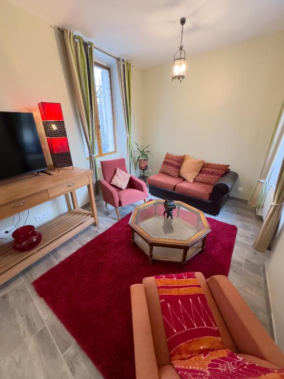 a living room with a couch and a table at Magnifique maison entière, meublée tout confort et son jardin clos privé in Villeblevin