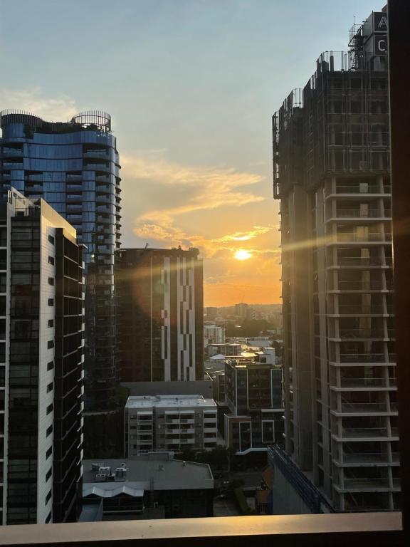 a sunset in a city with tall buildings at Views and Vibes - Free Parking - great location! in Brisbane