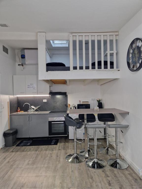 a kitchen with a counter and a table and chairs at maison individuelle à Drancy in Drancy