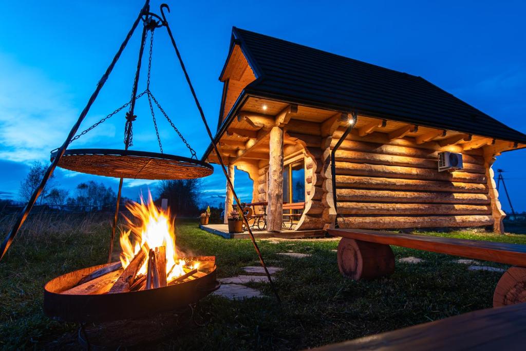 a fire pit in front of a log cabin at Góralskie Domki u Topora in Czarny Dunajec