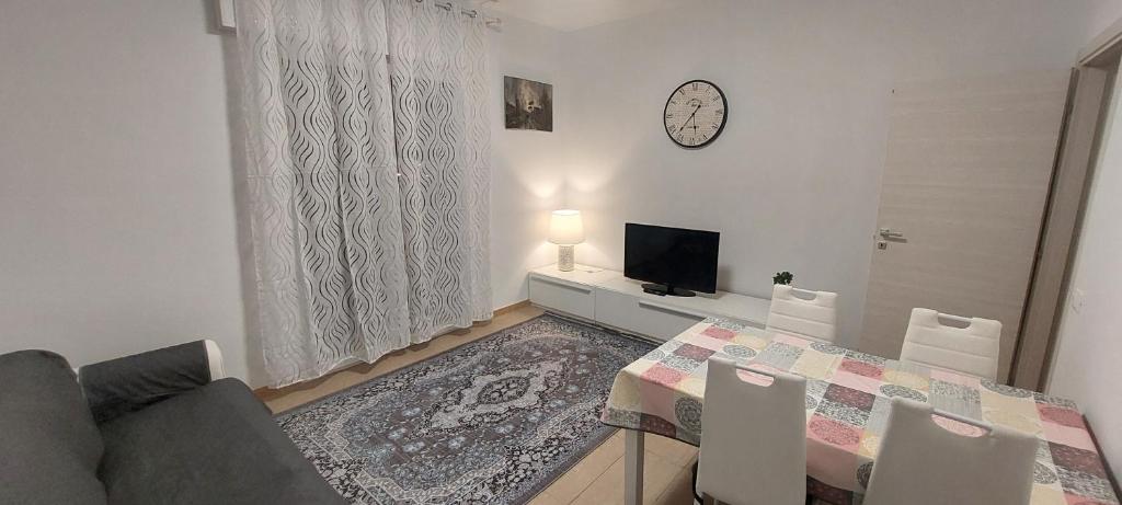 ein Wohnzimmer mit einem Esstisch und einem TV in der Unterkunft Comodo a tutti servizi in Abano Terme