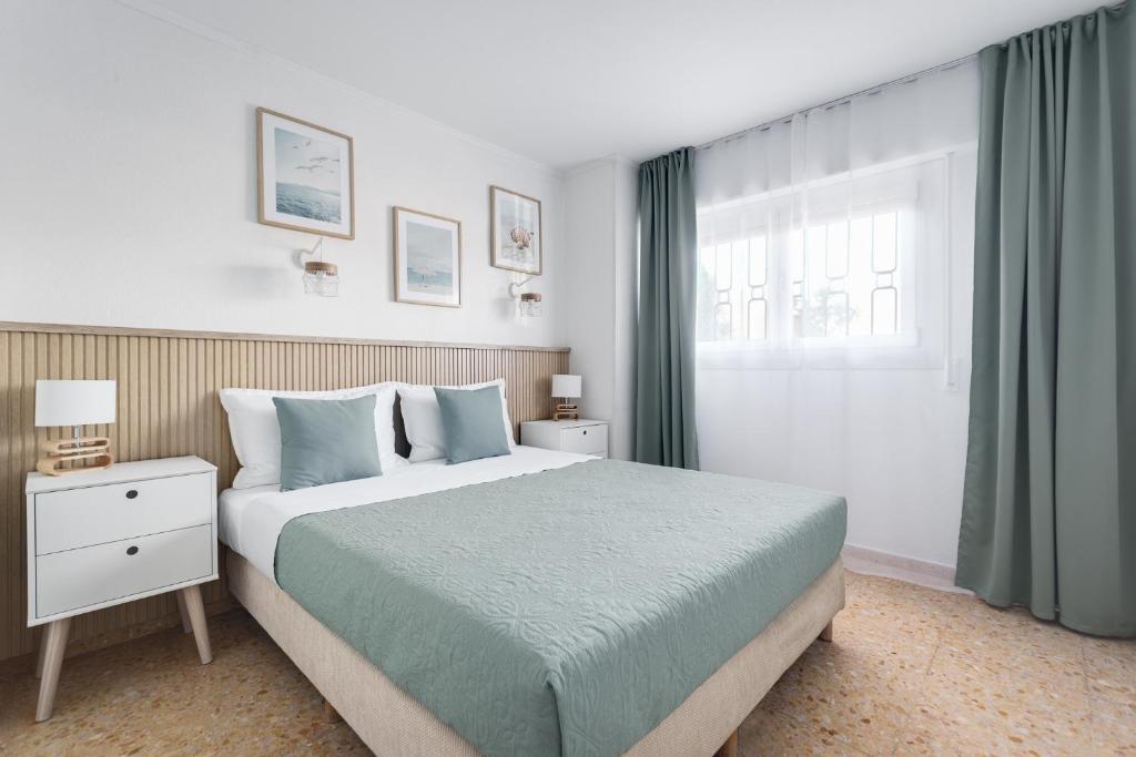 a bedroom with a large bed and a window at Europa Club Apartment, La Cala de Finestrat, Benidorm, Next to the beach, Ground floor, Air Cond in Benidorm