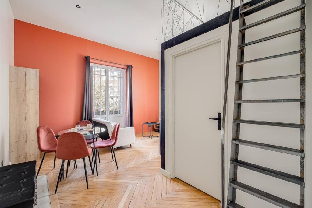 une porte ouverte menant à une salle à manger aux murs orange. dans l'établissement L’exo chic Fauriel appartement refait à neuf, à Saint-Étienne