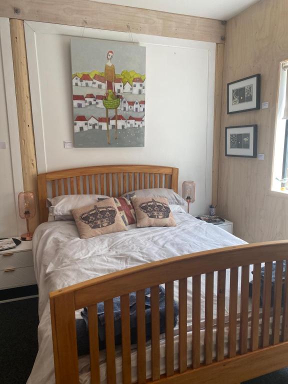 a bedroom with a bed with a wooden crib at Stay at the art gallery in Mapua