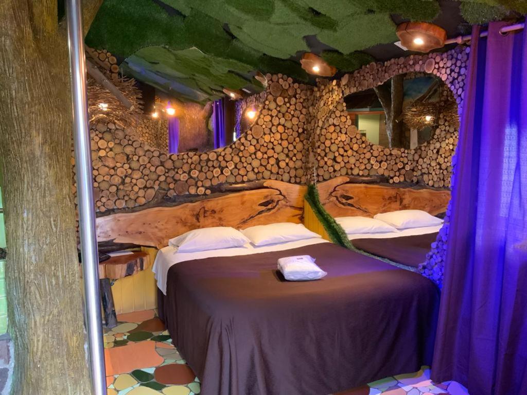 - une chambre avec 2 lits dans une pièce avec un mur dans l'établissement Hotel Boutique El Duende Mantagua, à Quintero