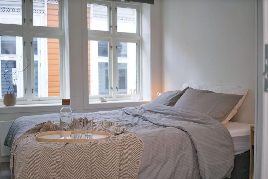 Un dormitorio con una cama con una mesa con una botella. en Vestre Murallmenningen, en Bergen
