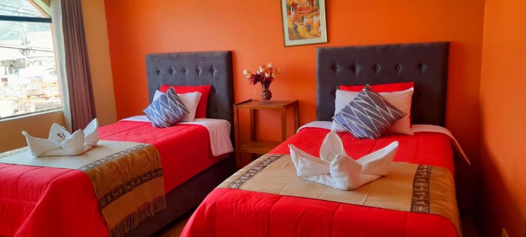 two beds in a room with orange walls at Sumac wasi in Chivay