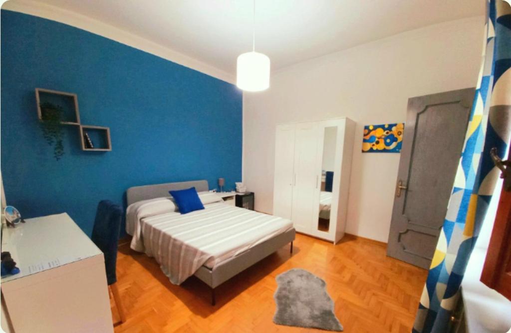 a bedroom with a bed and a blue wall at Affittacamere Osimo Rose in Osimo
