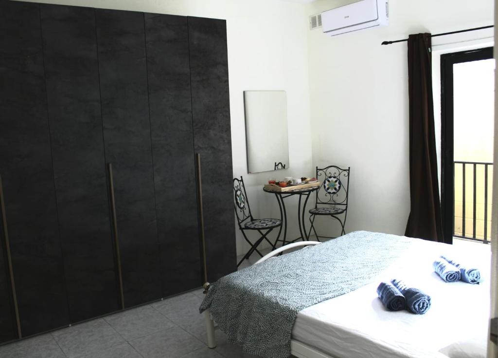 - une chambre avec un lit et une table avec une chaise dans l'établissement Le 3 isole, à Marsaskala