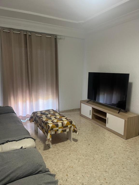 sala de estar con TV de pantalla plana y sofá en CASA FRANCISCO, en El Cuervo