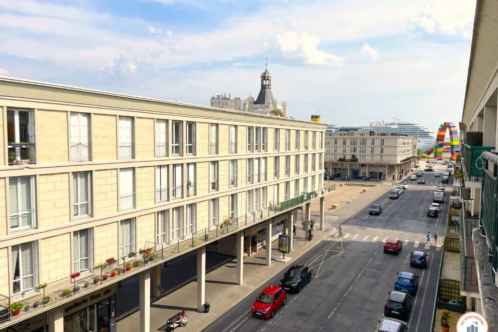 - une vue sur une rue avec un bâtiment et des voitures dans l'établissement La Catène - Balcon - Vue Catène, au Havre