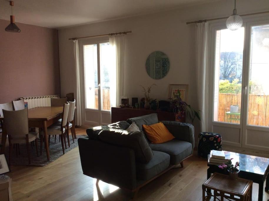 uma sala de estar com um sofá e uma mesa em Appt 90 m2, quartier tranquille em Grenoble