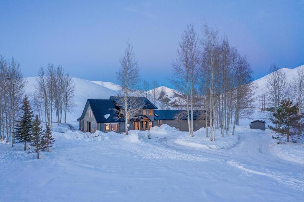 une maison avec un toit bleu dans la neige dans l'établissement Gorgeous Log Cabin Close to Town with Hot Tub, à Hailey