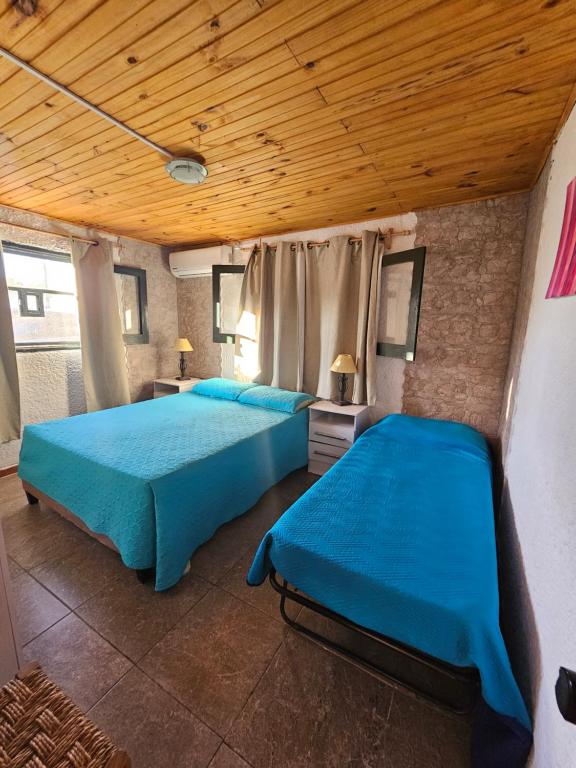 sypialnia z 2 łóżkami i drewnianym sufitem w obiekcie Ave Fénix w mieście Aguas Dulces