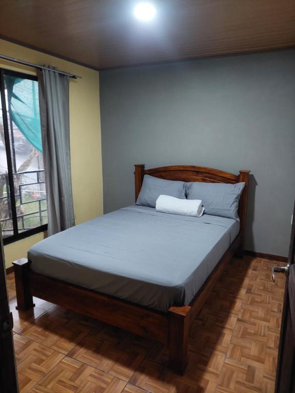 um quarto com uma cama num quarto com uma janela em Anchia em Alajuela