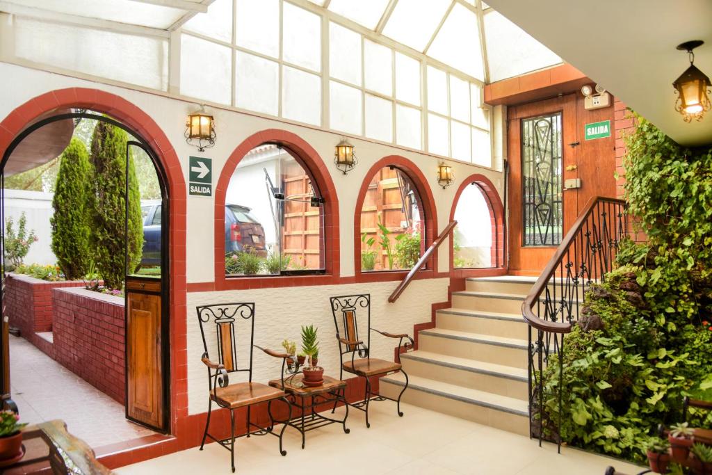 arium of a building with stairs and tables and chairs at Hotel Benavides in Arequipa