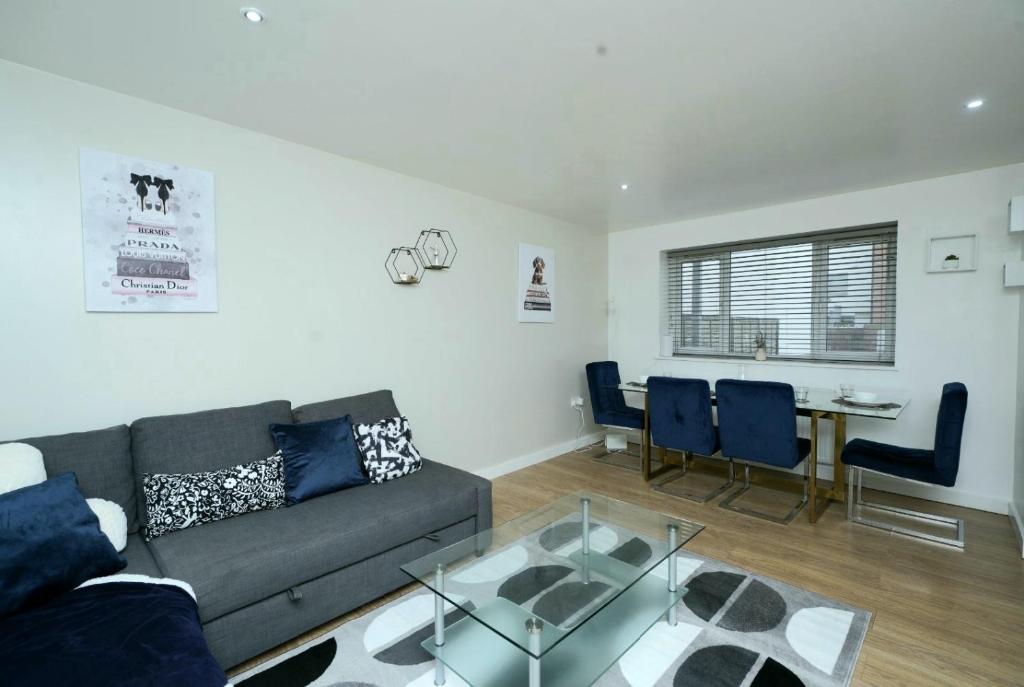 a living room with a couch and a table at Luxe & Stylish Central Luton 2Bed Apt - Fast Wi-Fi & Private Patio in Luton