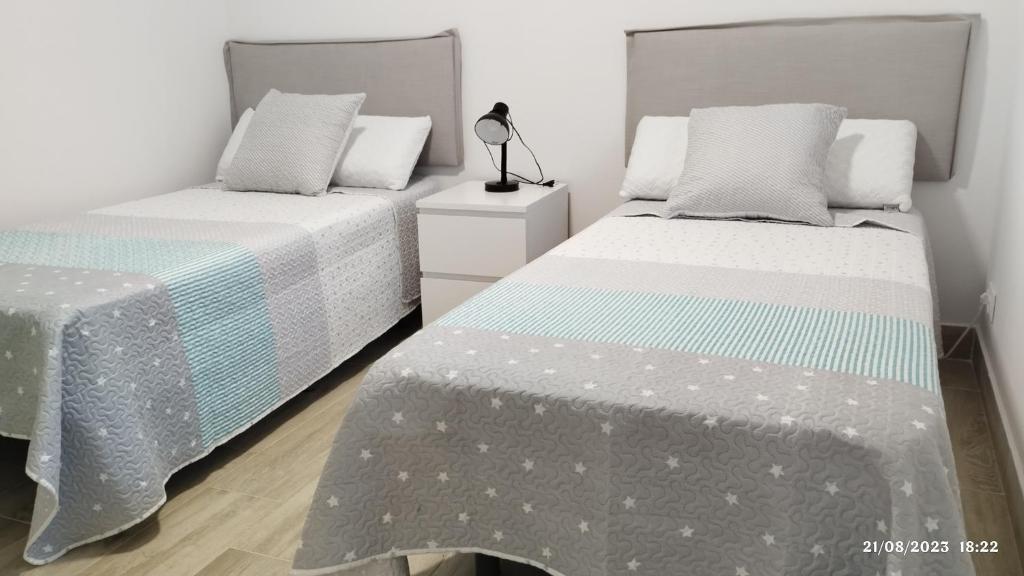 two beds sitting next to each other in a bedroom at Apartamento Agradables 3 in Madrid