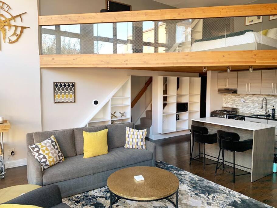 a living room with a couch and a kitchen at Lincoln Park Light-Filled Loft in Chicago