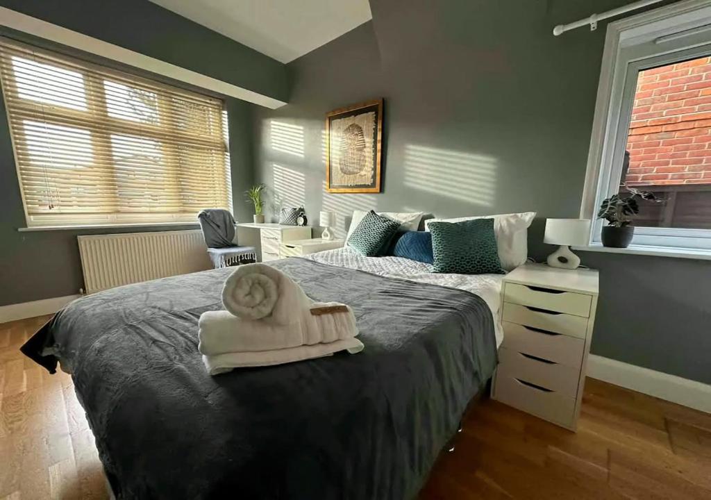 una camera da letto con un grande letto e un asciugamano di The Gemstone Manor a Watford