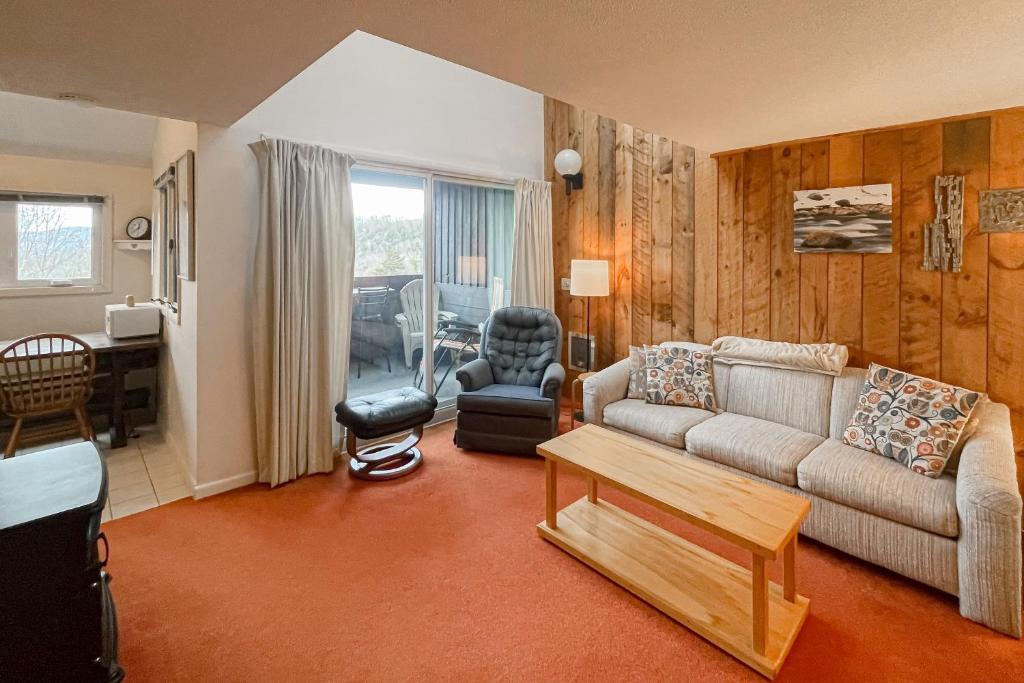 sala de estar con sofá y mesa en White Mountain Adventures en Campton