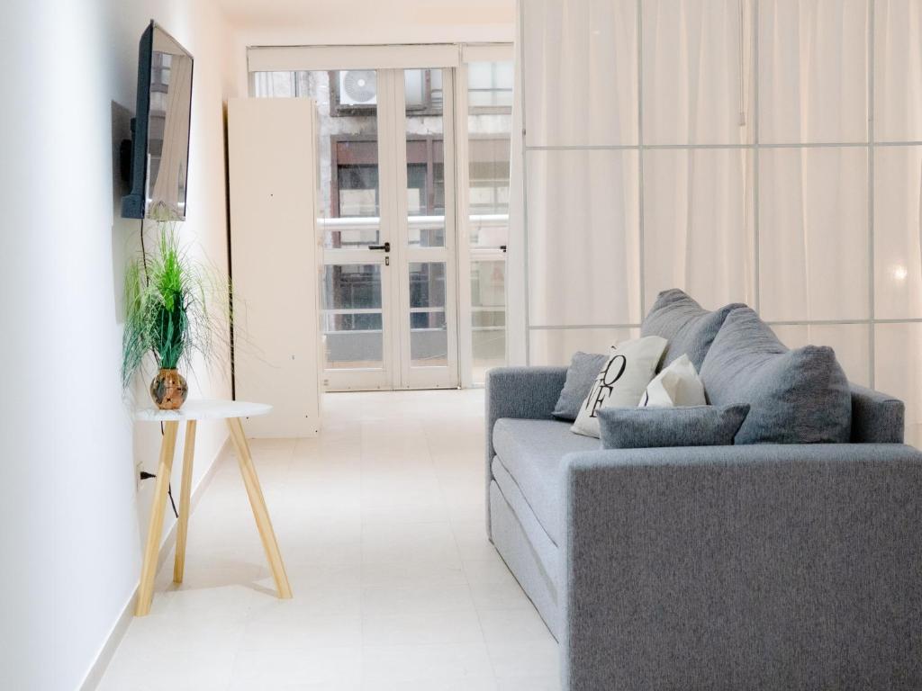 a living room with a couch and a tv at BORGES HOUSE APARTS Aparts con cochera a dos cuadras del obelisco in Buenos Aires