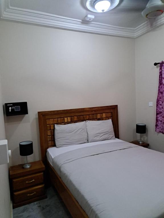 sypialnia z łóżkiem i 2 szafkami nocnymi z lampkami w obiekcie Brufut Residence w mieście Brufut