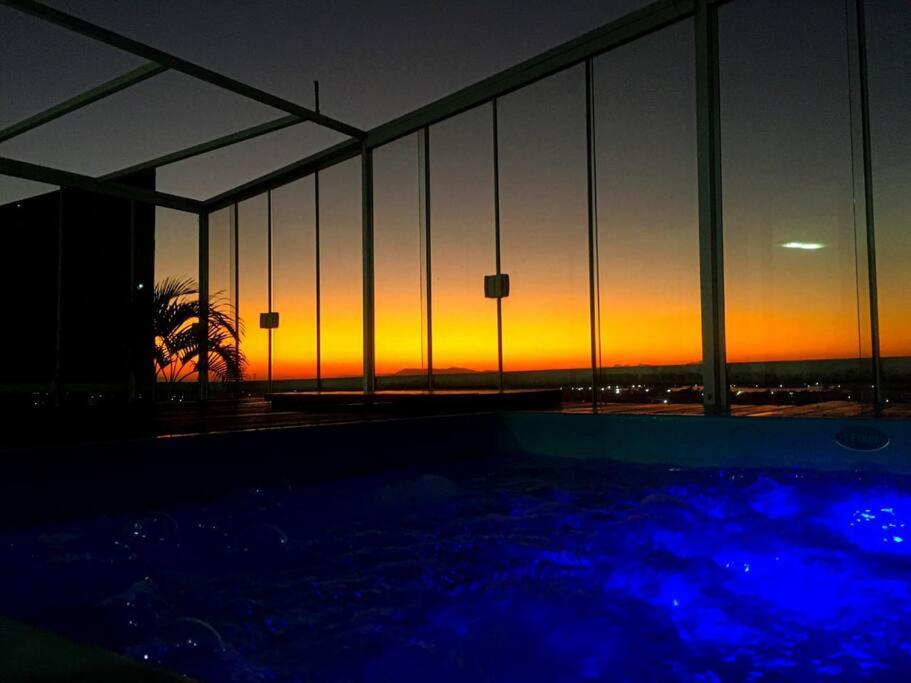 un tramonto visto attraverso le finestre di un edificio di Excelente Cobertura Duplex a Cabo Frio