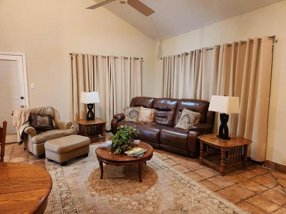 a living room with a leather couch and a table at Casita #5 @ Riverhill in Kerrville
