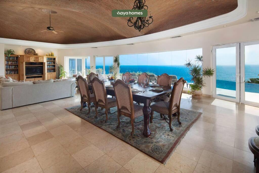 a dining room with a table and chairs and the ocean at Cliffside 8BR Villa with Breathtaking Views - Pool in Cabo San Lucas