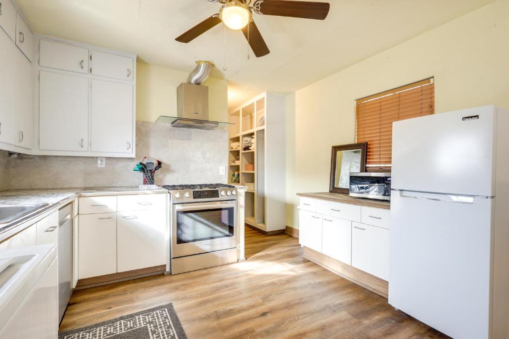 uma cozinha com armários brancos e um frigorífico branco em Home with Yard about 2 Mi to University of New Mexico! em Albuquerque