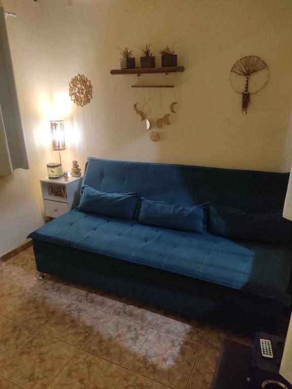 un sofá azul sentado en una sala de estar en Casa famíliar, en Río de Janeiro
