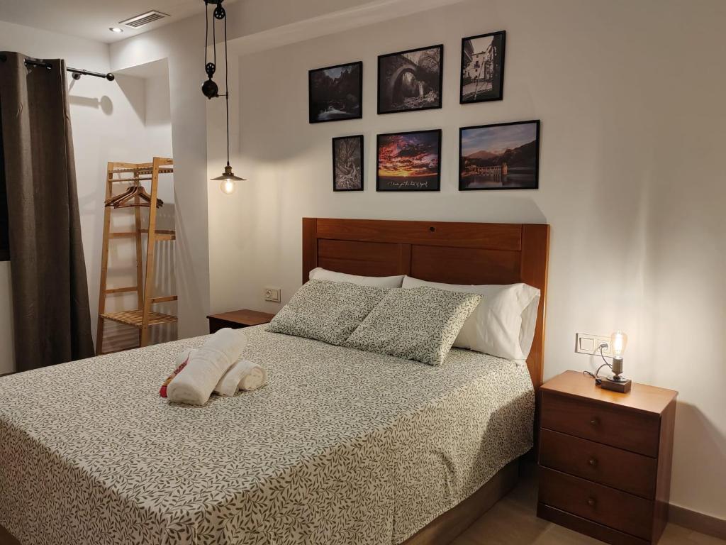 a bedroom with a bed and some pictures on the wall at La Noguera Rural Suite in Güéjar-Sierra