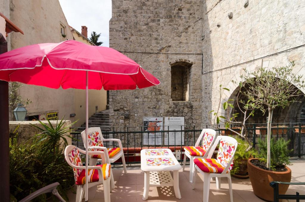 a group of chairs and an umbrella on a patio at Apartment & Room Dubrovnik Sweet Home in Dubrovnik